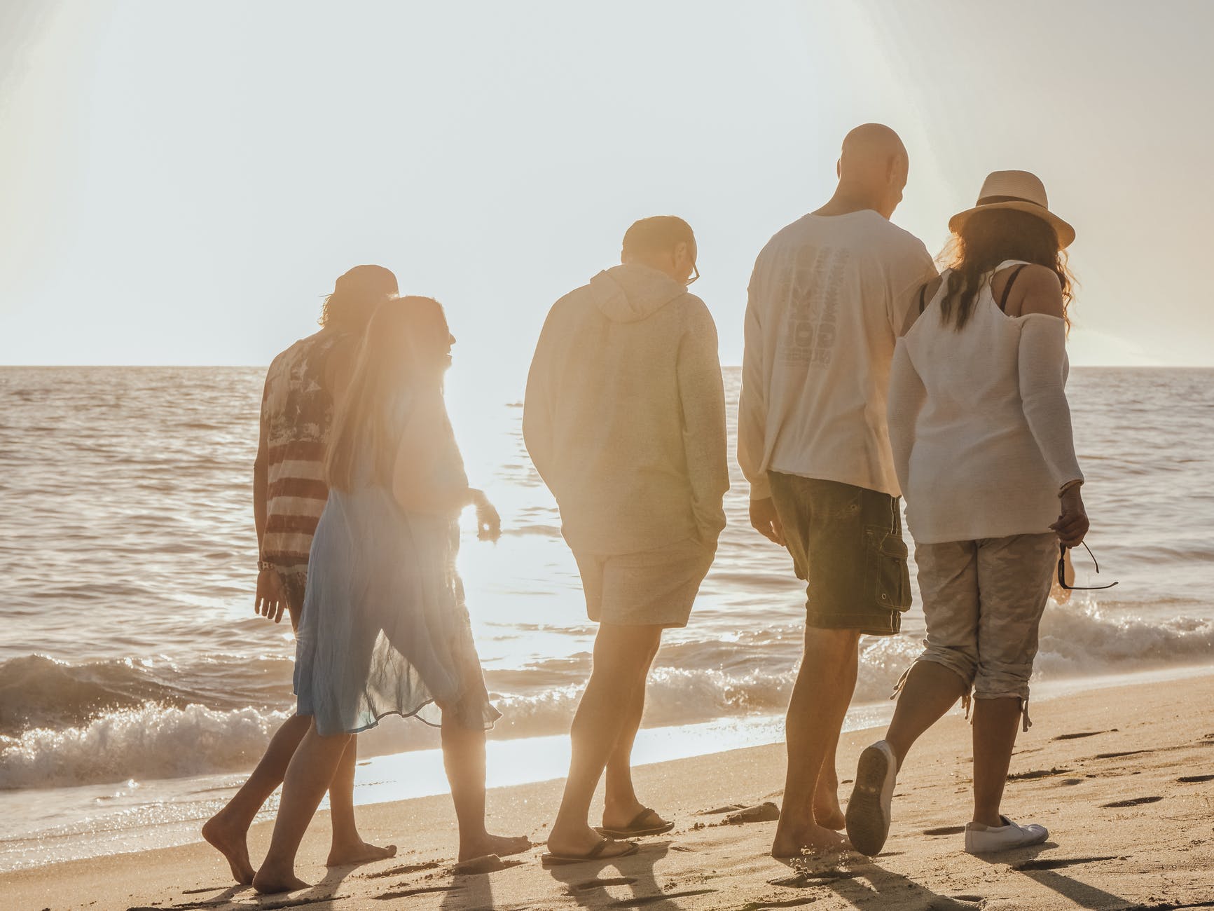 man and woman walking on beach